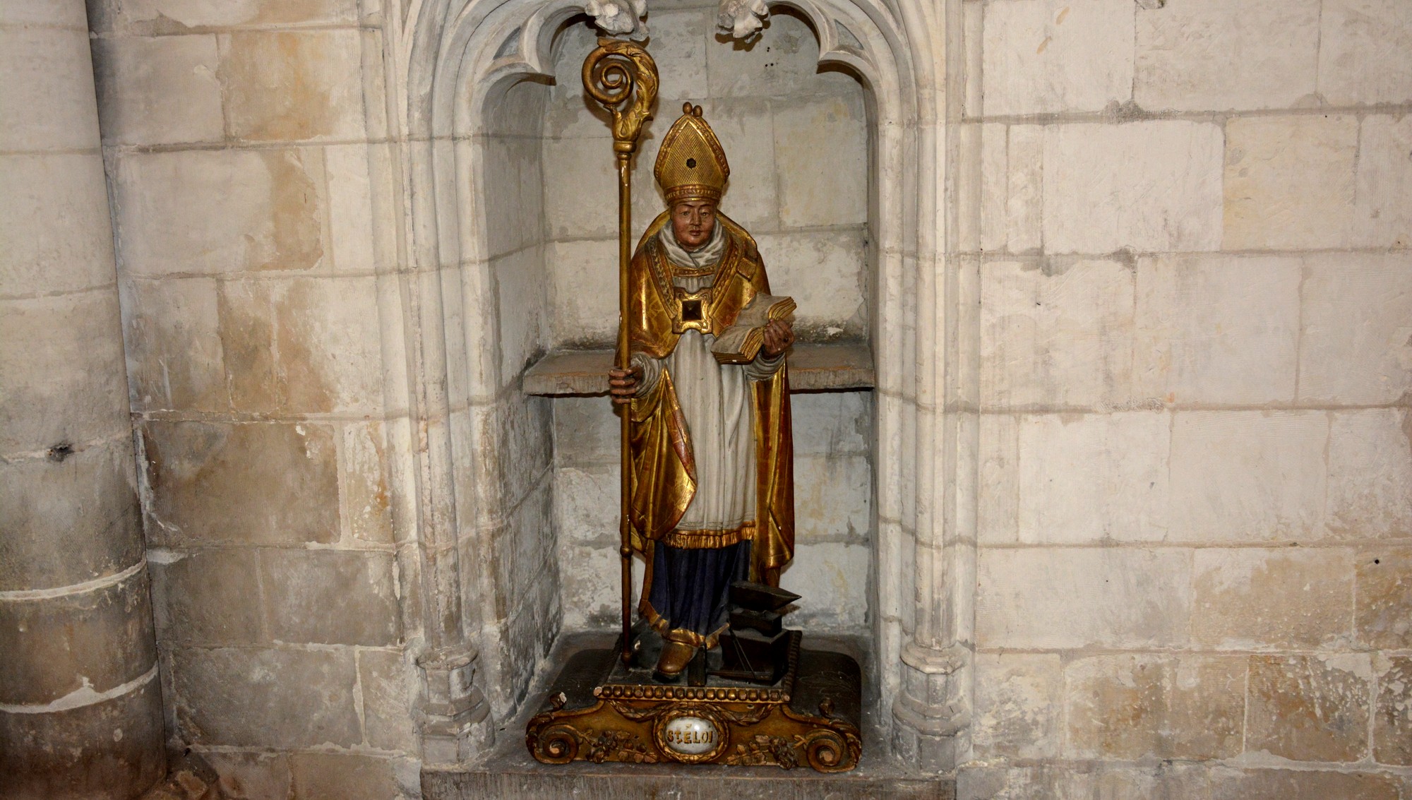 Le bon saint Eloi, orfèvre à la cour du roi Clotaire II dont il sera ensuite le trésorier, deviendra le principal conseiller du roi Dagobert. Eloi, devenu prêtre puis évêque de Noyon auprès du second souverain, consacre sa vie à secourir les pauvres et à racheter les esclaves. Les fidèles lui attribueront des travaux d'orfèvrerie prestigieux, notamment des châsses, et de nombreux miracles après sa mort. Eloi aurait coupé la patte d'un cheval pour le ferrer plus facilement, avant de la remettre en place. Il aurait également reconduit le diable, déguisé en femme afin de le tenter, en lui attrapant le nez avec des tenailles.