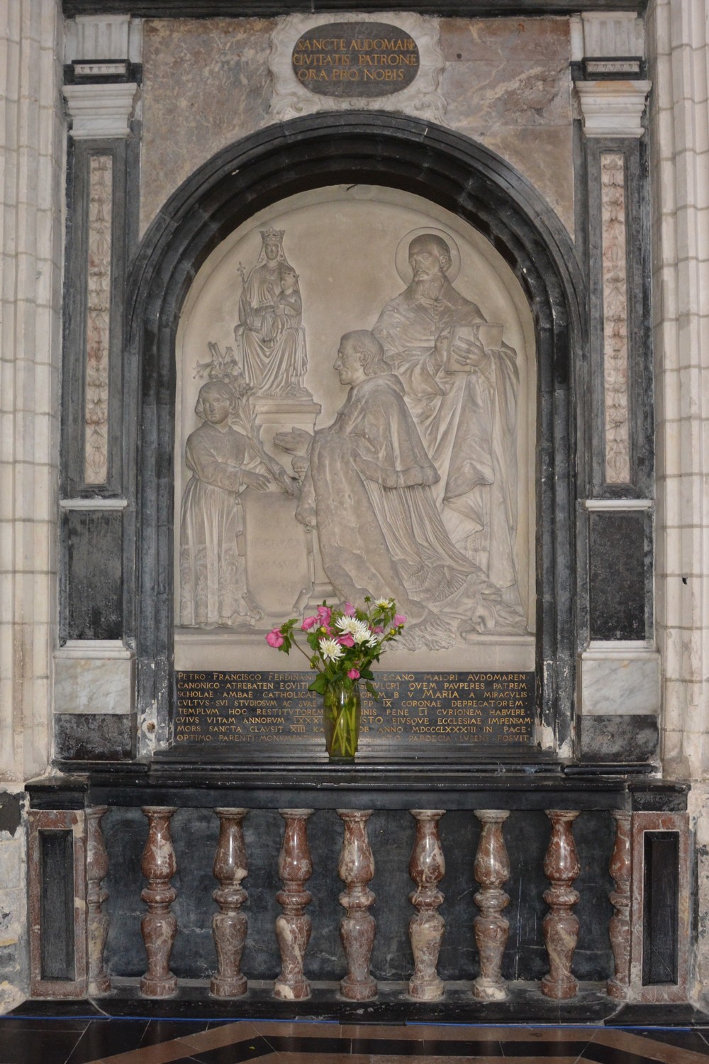  Bas-relief en pierre blanche, œuvre du sculpteur Louis Noël et représentant M. le chanoine Duriez grand-doyen et le restaurateur des pèlerinages