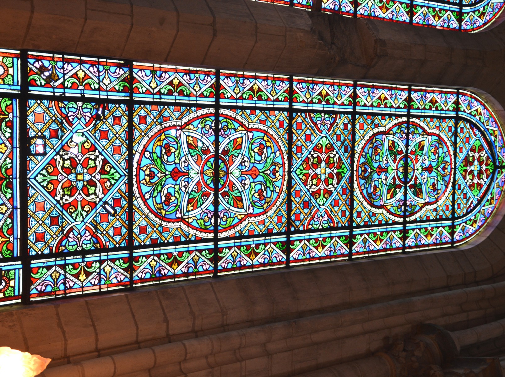 Cathédrale de Saint-Omer | Déambulatoire  vitraux travée 07, Deux vitraux à deux formes couronnés chacun par un quatrefeuille. Décor géométrique ; bustes de saint Pierre et saint Paul dans les quatrefeuilles. 1874 ; ateliers A. Lusson et L. Lefèvre (Paris). Hauteur : 5,00 m environ. Largeur : 3,00 m environ.